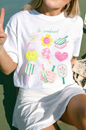 White polyester t-shirt with playful pickleball and floral graphic print and text.