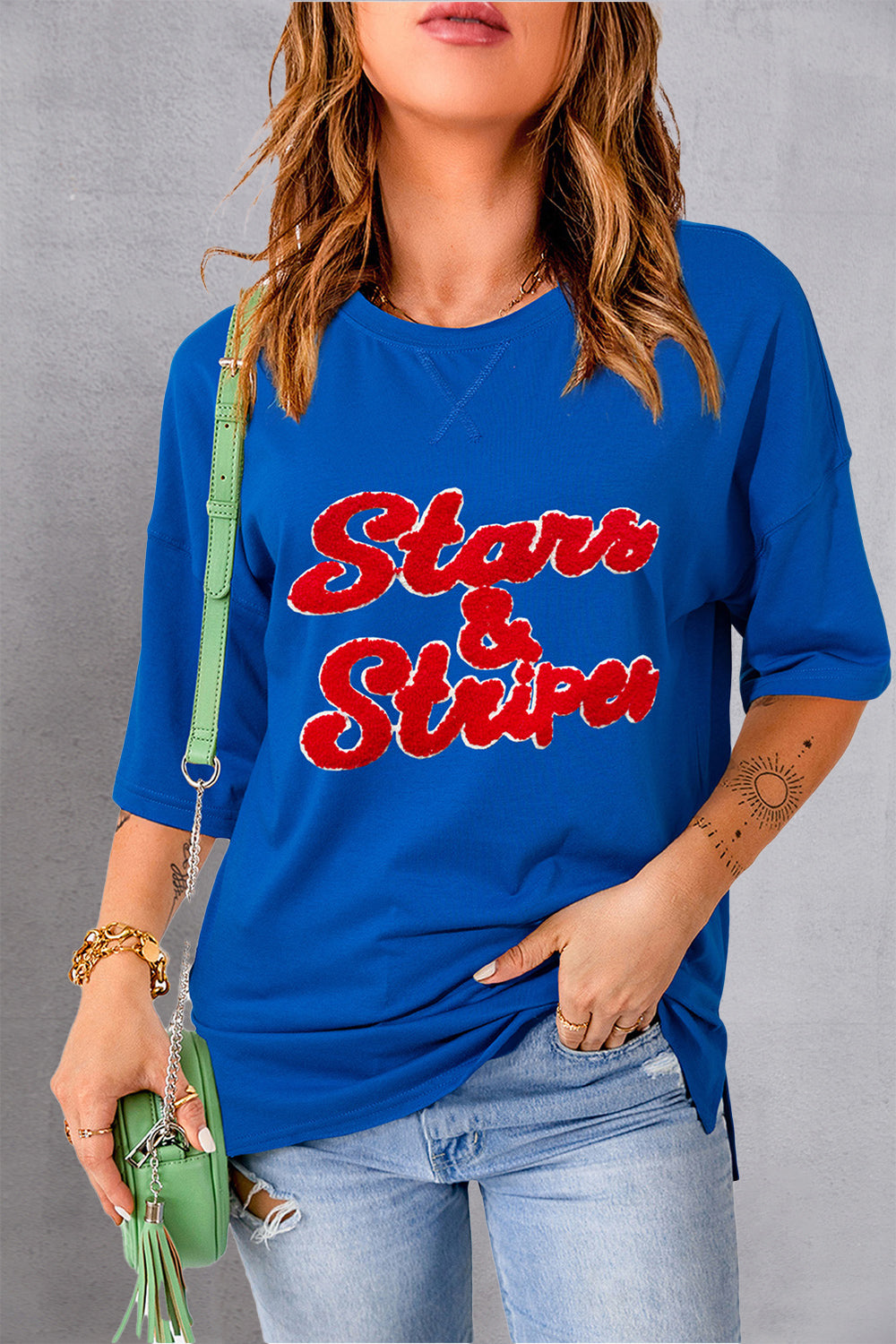 Royal blue slouch tee with red embroidered Stars & Stripes graphic, crew neck, and short sleeves.