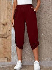 Burgundy culottes with button details and cinched hems, cropped length.