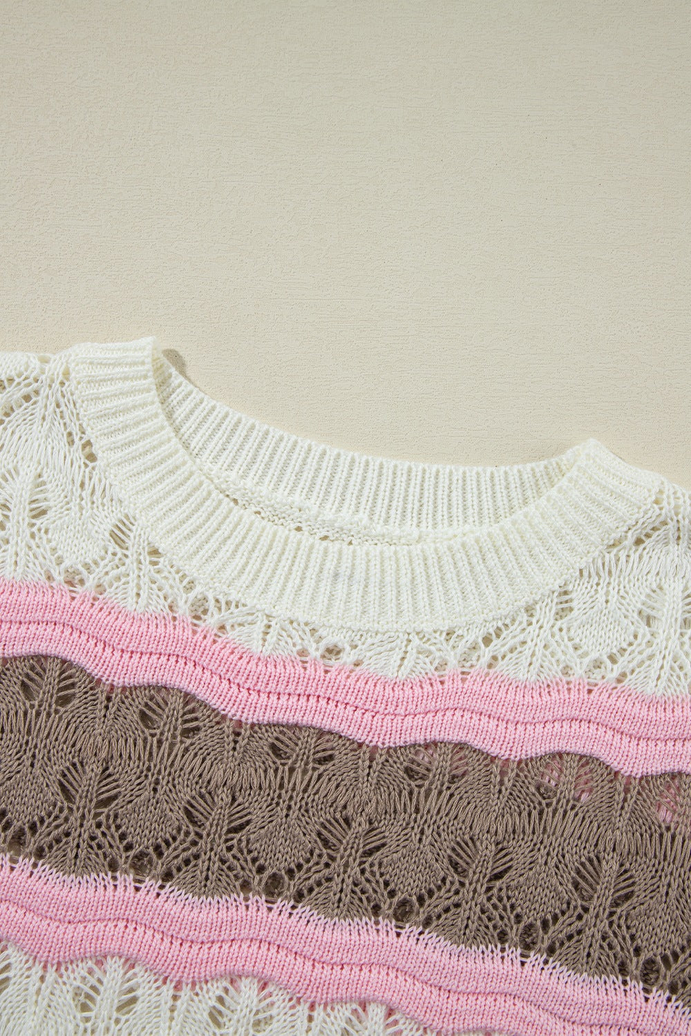 Striped openwork knit top with crew neck and wavy pink and taupe stripes.