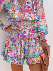 Abstract tiered dress with ruffles and paisley print in vibrant colors.