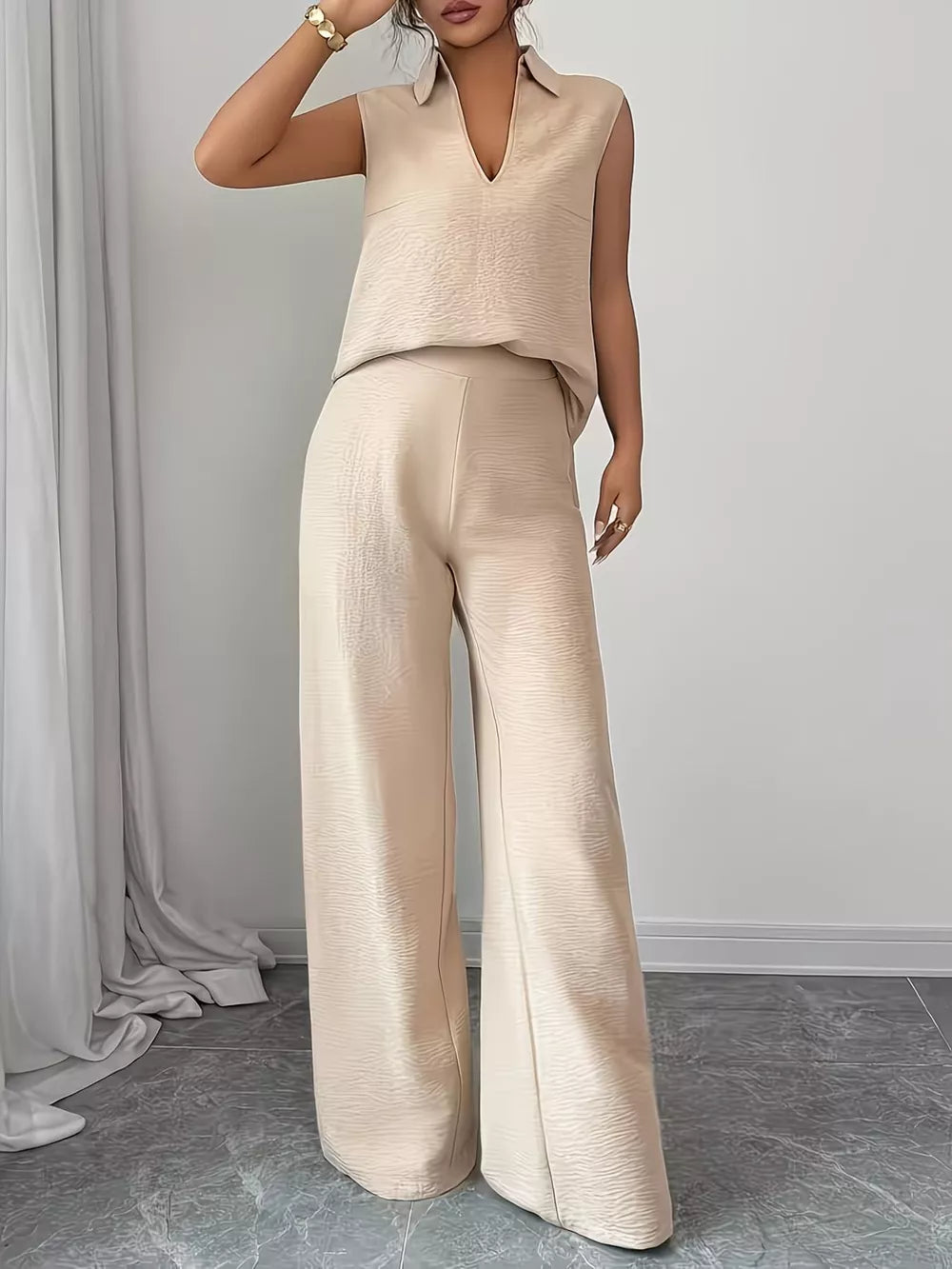 Beige sleeveless collared top and wide-leg pants set with textured fabric.