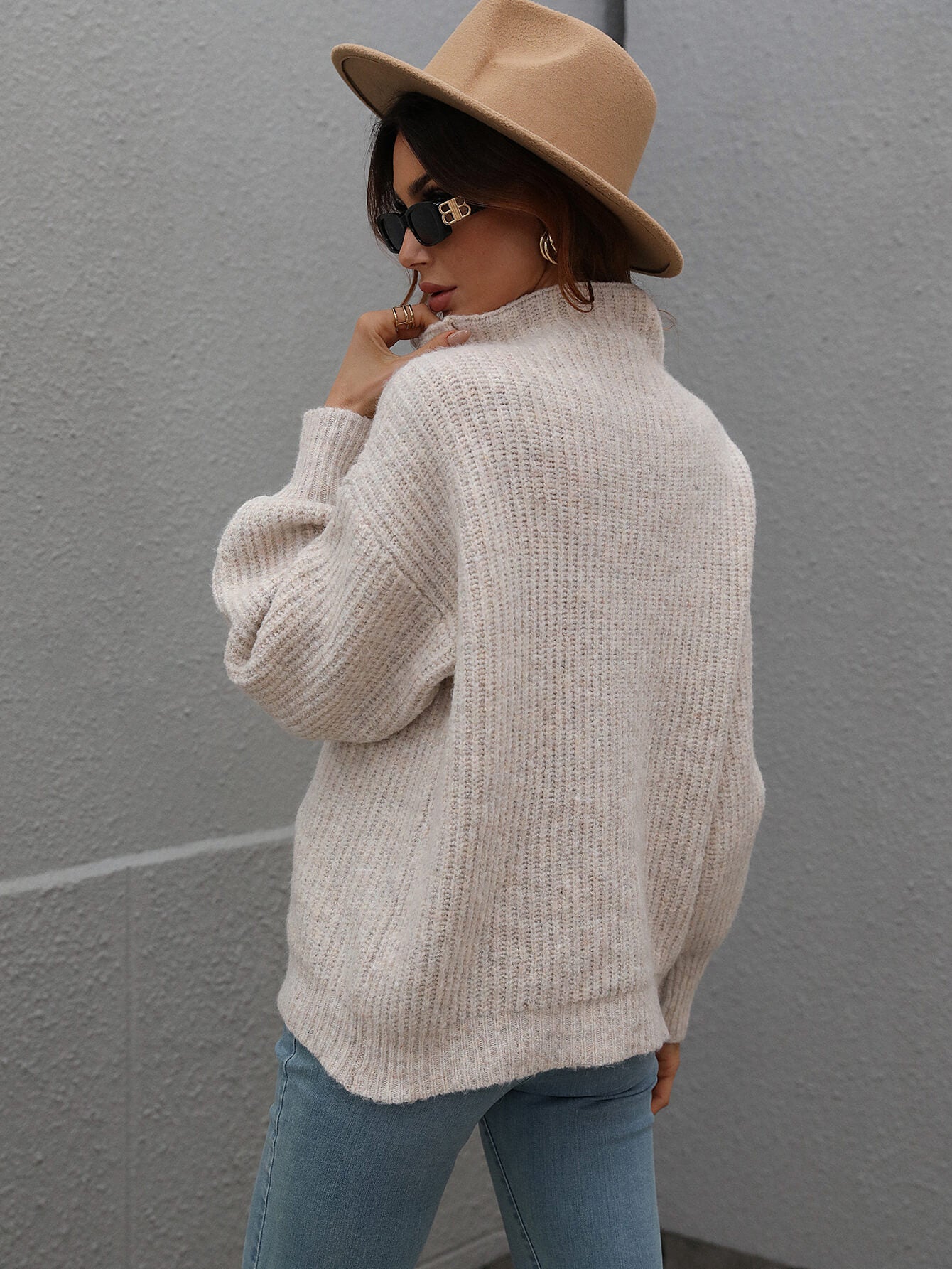 Beige ribbed knit turtleneck sweater with balloon sleeves.