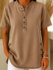 Denim-inspired khaki short sleeve button blouse with band collar and side buttons.