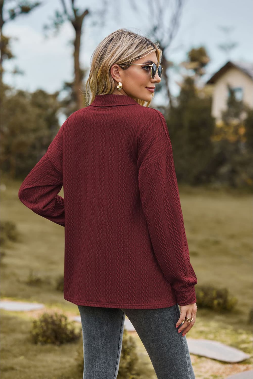 Burgundy textured knit polo shirt with a collared neckline and long sleeves.