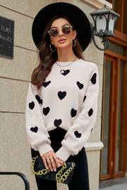 Beige and black heart jacquard knit sweater with balloon sleeves and crew neck.