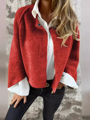 Red fuzzy knit cardigan with button detail and white shirt cuff detail.