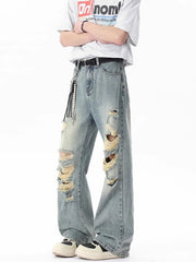 Men's light blue distressed wide-leg jeans with frayed details and a pearl chain accessory.