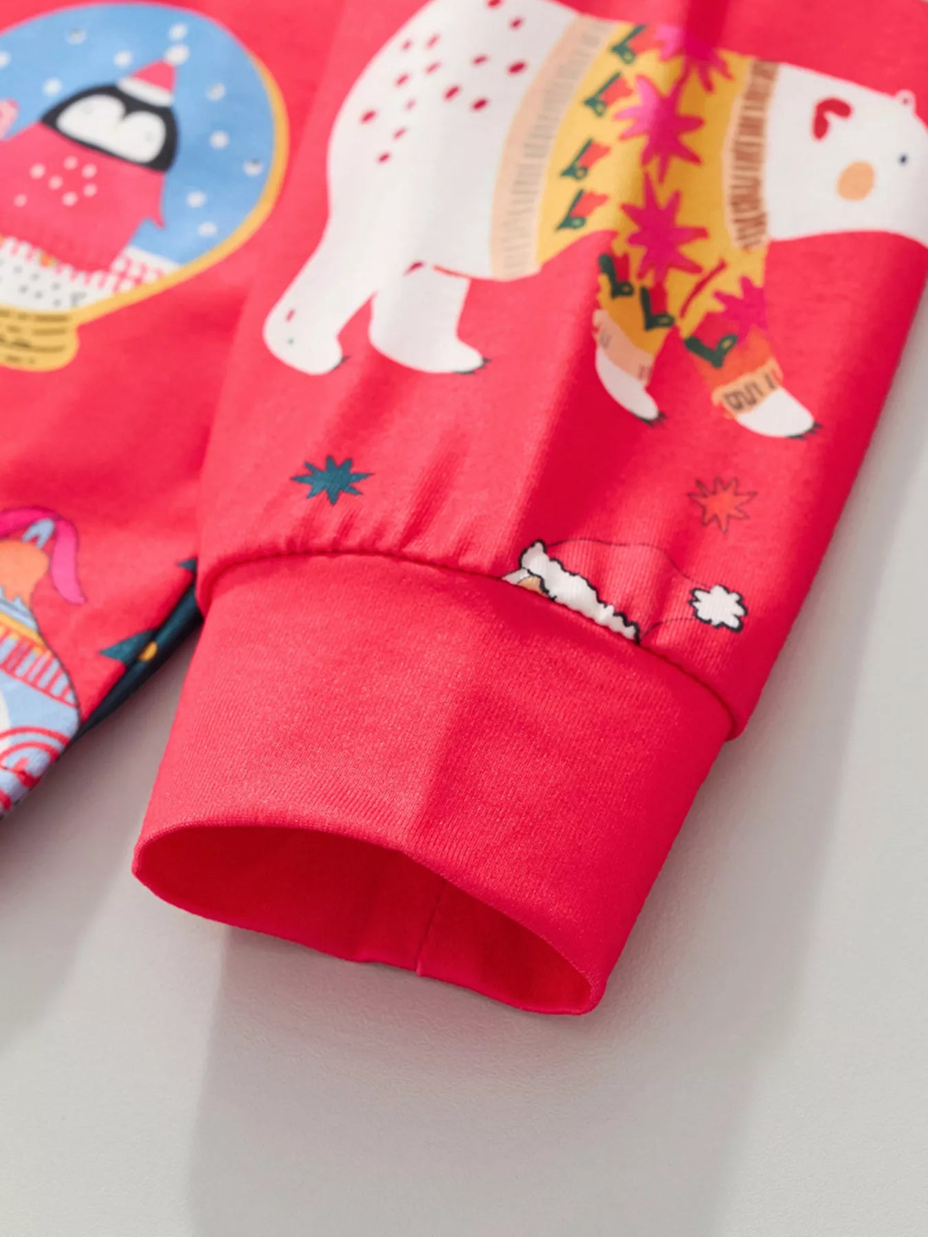 Children's red Christmas pajama set with polar bear and penguin print.