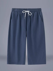 Relaxed fit cropped sweatpants in dark blue with drawstring waist and side pockets.
