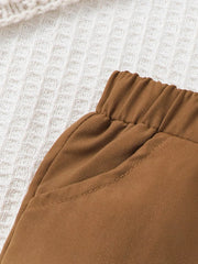 Brown baby pants with elastic waistband and stitched pocket detail.