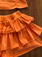 Orange ruffled skirt ensemble with tiered ruffles and a cami top detail.