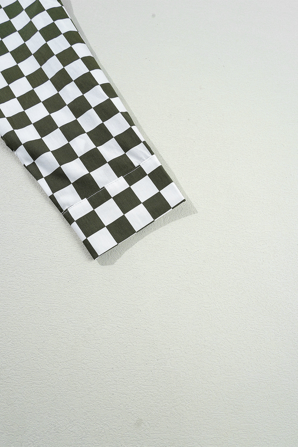 Olive and black checkered button-down shirt sleeve detail