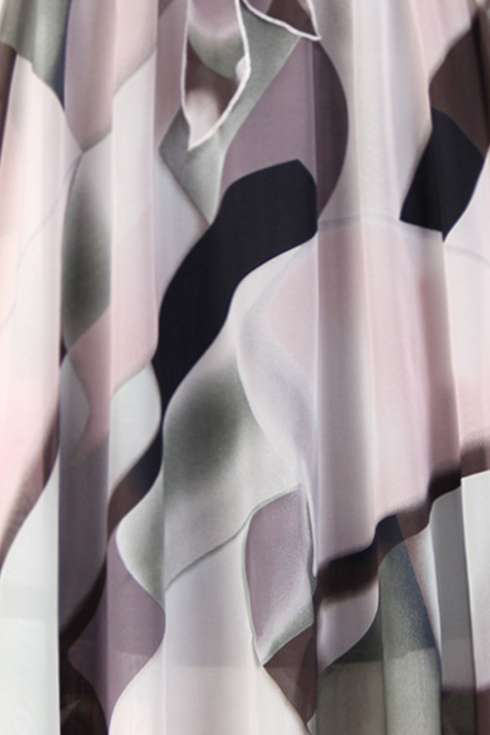 Chiffon midi skirt with abstract magnolia print in blush pink, dark blue, and black.