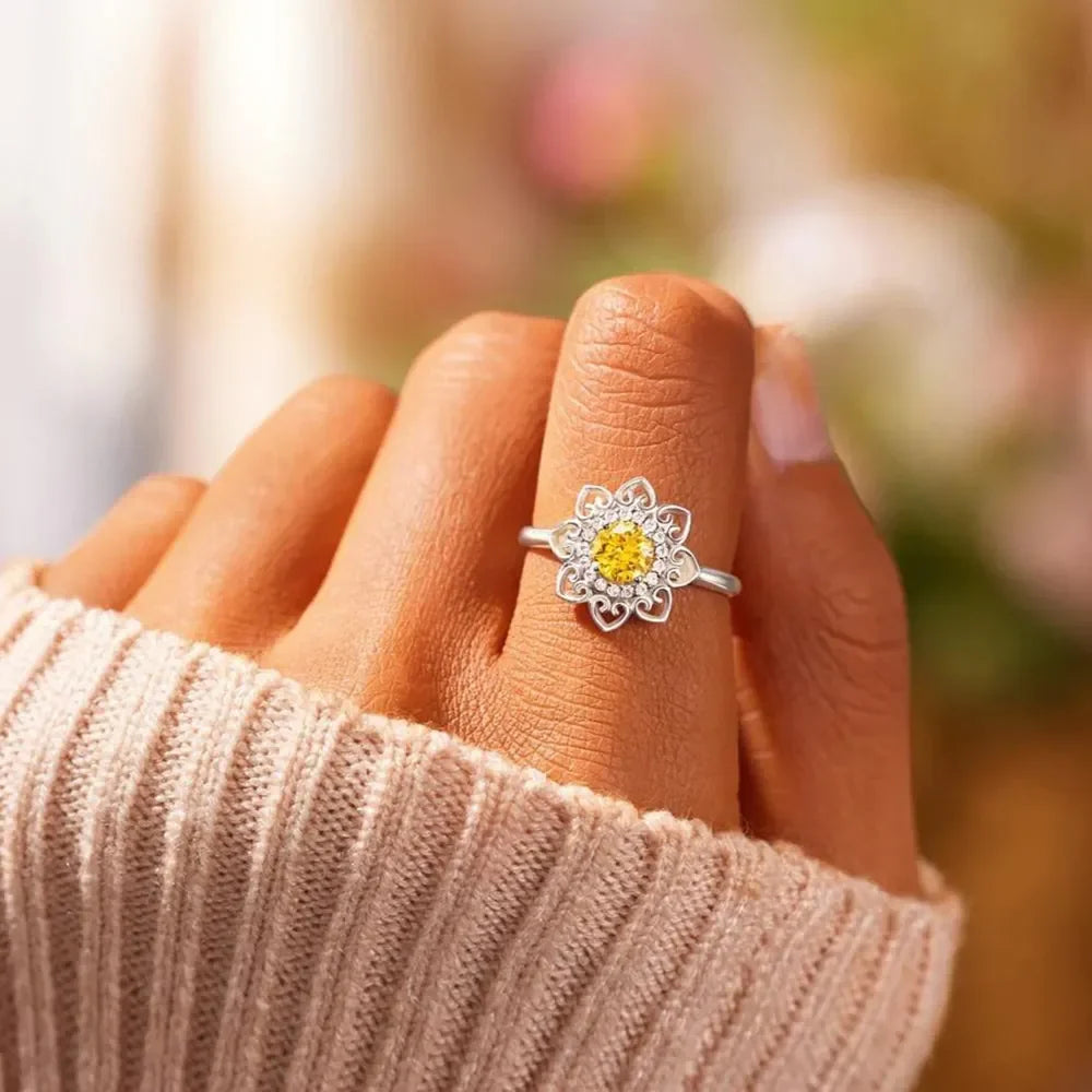 Silver floral filigree ring with yellow and clear zirconia stones.
