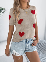 Tan knit t-shirt with red heart pattern and short sleeves.