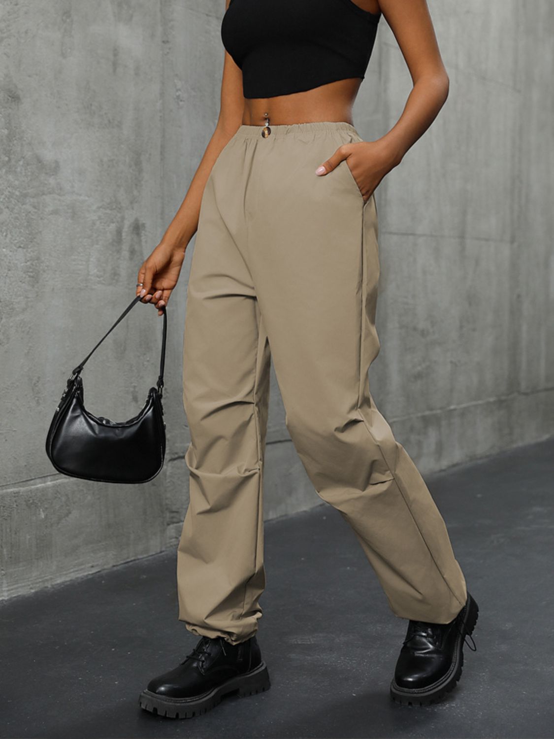 Khaki gathered-leg utility trousers with cuffed ankles and drawstring waist.