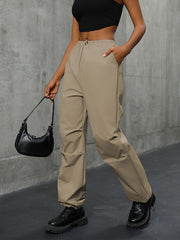 Khaki gathered-leg utility trousers with cuffed ankles and drawstring waist.