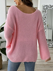Pink slouchy boatneck knit sweater with wide sleeves and ribbed texture.