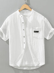 White textured cotton short sleeve button-up shirt with mandarin collar and chest pocket.