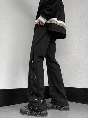 Men's black snap button loose fit sweatpants with adjustable ankle detail.