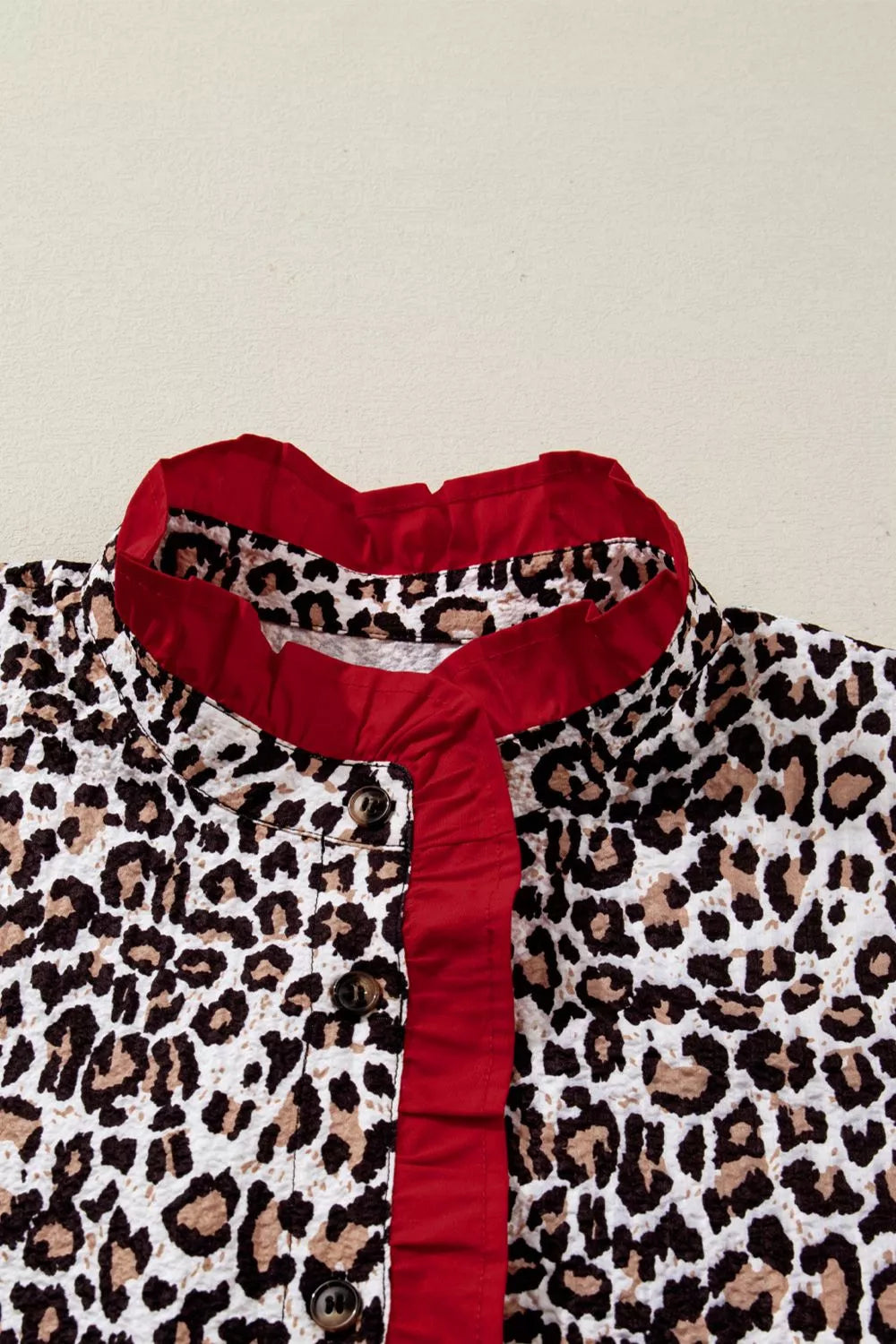 Leopard print polyester shirt with red frilled V-neck and buttons