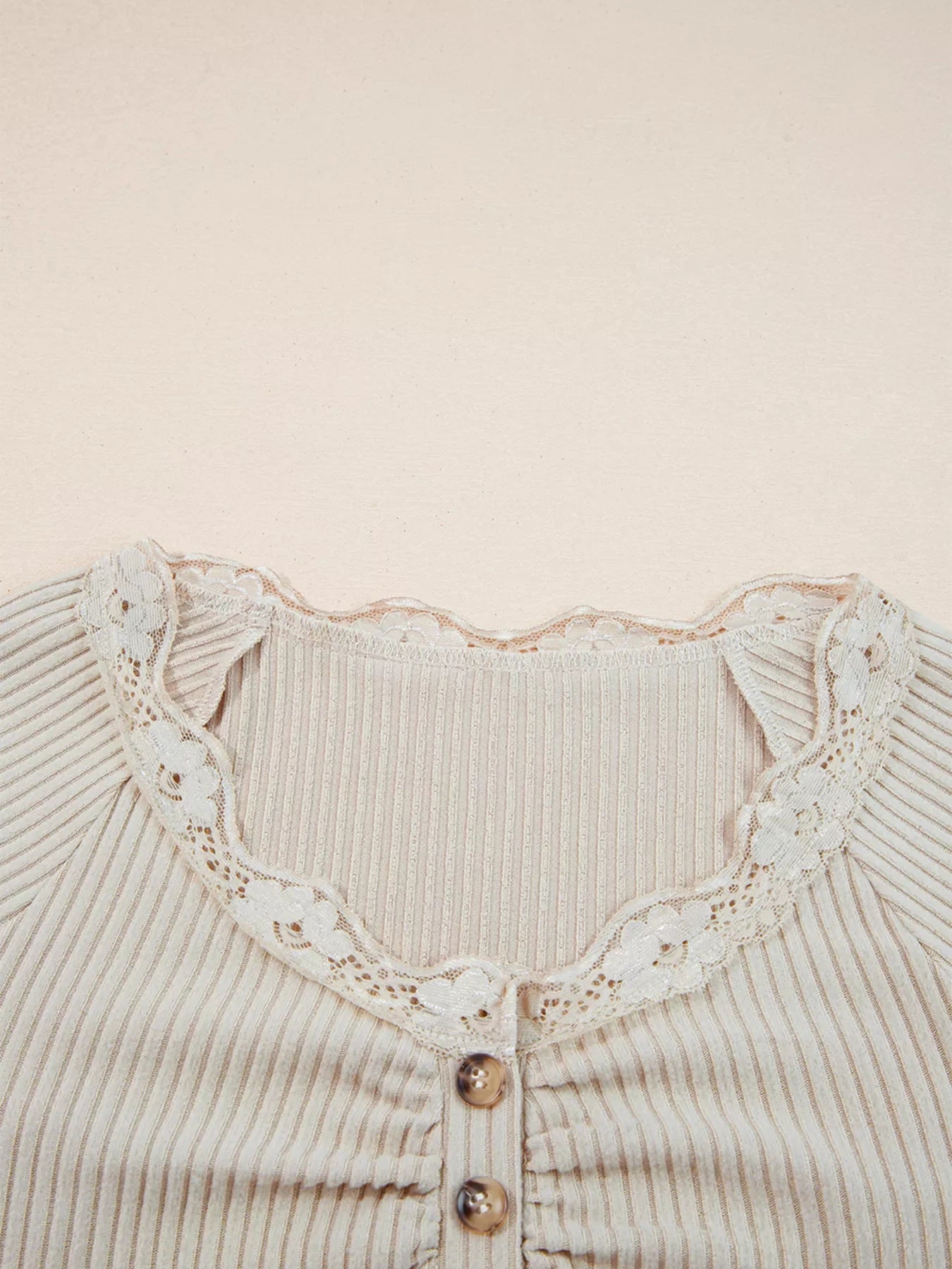 Beige ribbed long-sleeve top with delicate lace trim and button detail.