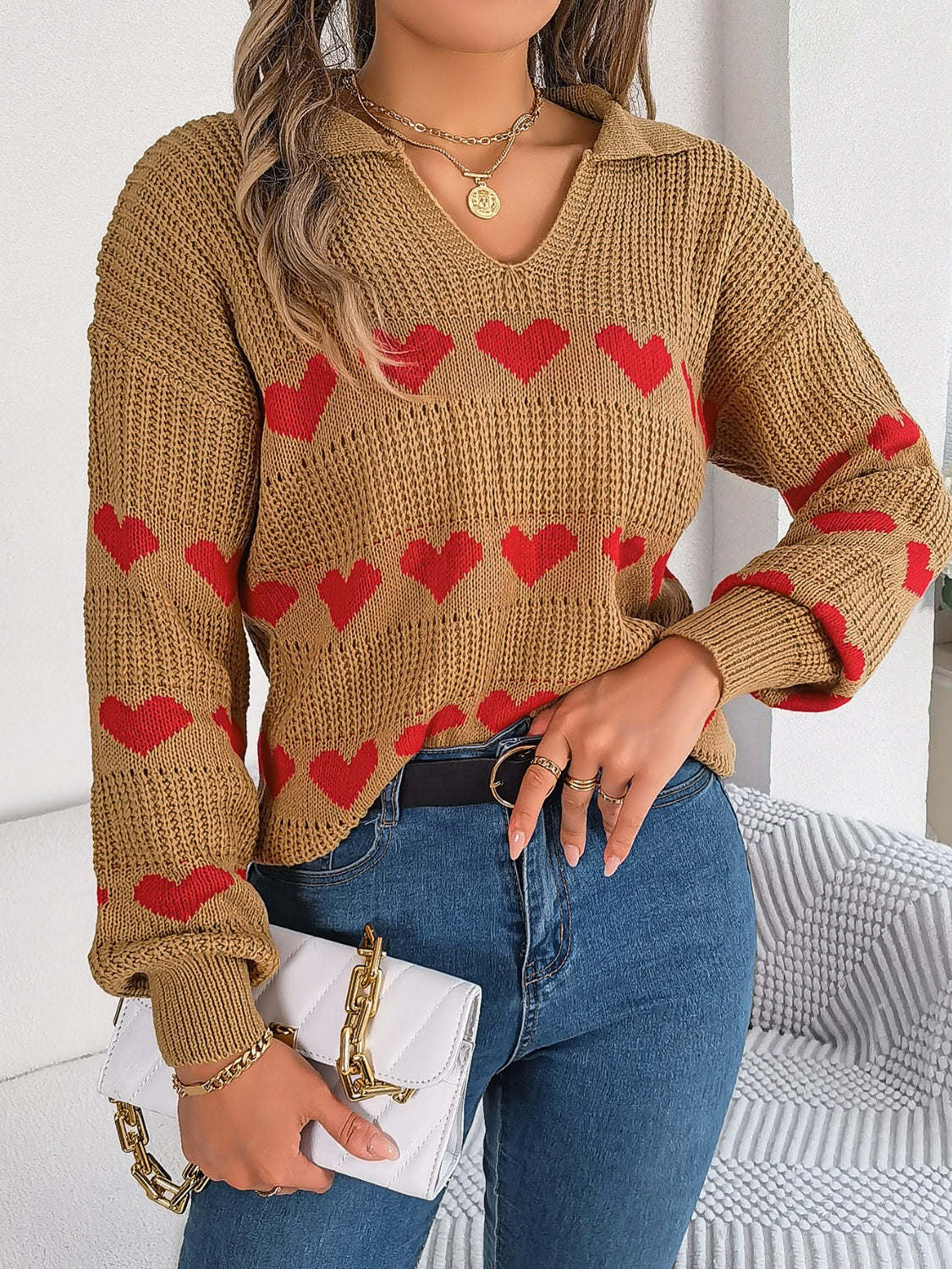Camel knit polo sweater with red heart pattern and long sleeves.