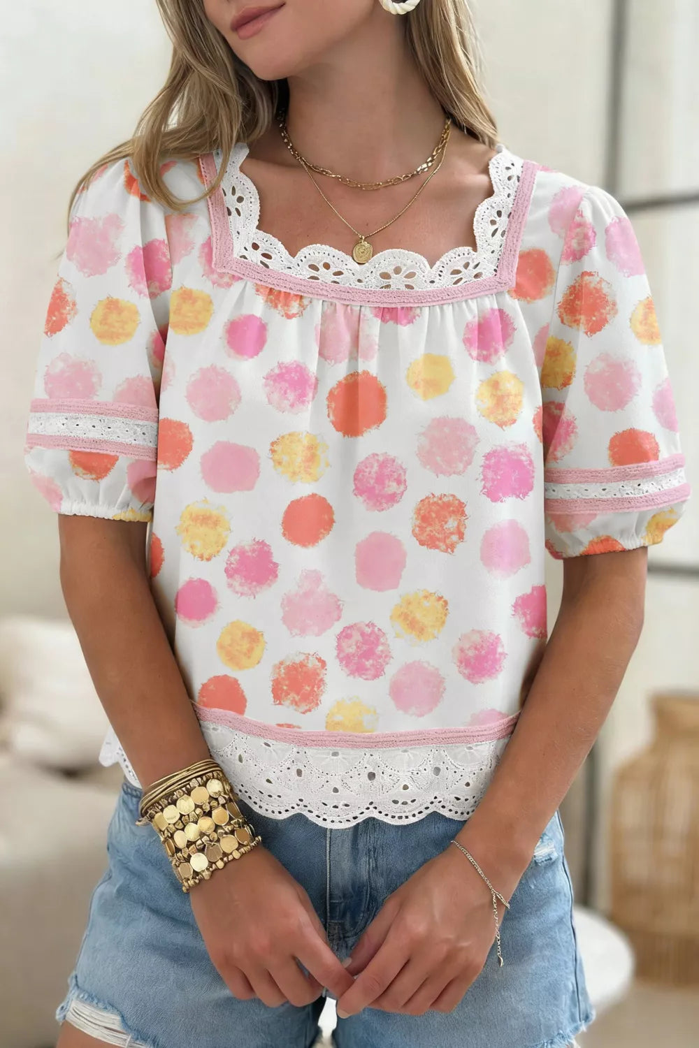 White polyester blouse with pink, orange, and yellow polka dots, puff sleeves, lace trim, and square neckline.