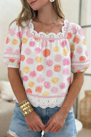 White polyester blouse with pink, orange, and yellow polka dots, puff sleeves, lace trim, and square neckline.