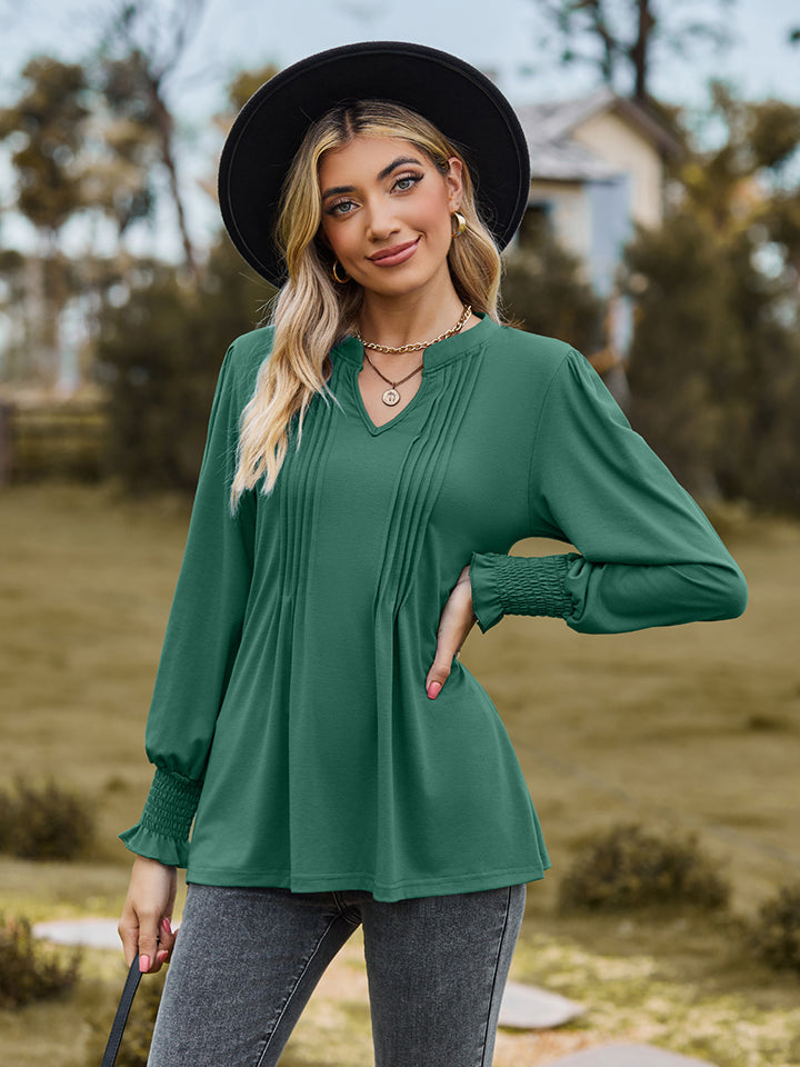 Green long sleeve blouse with pleated yoke and shirred cuffs.
