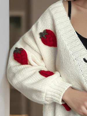 Cream knit cardigan with red strawberry appliqués on the sleeve.