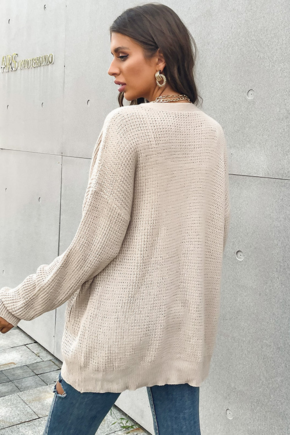 Beige waffle knit relaxed fit cardigan with pockets and button front.