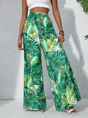 Green tropical leaf print palazzo trousers in 100% polyester with a wide leg