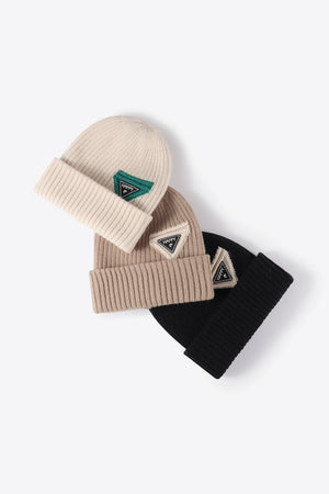 Ribbed acrylic beanies in beige, black, and cream with triangle "HAPPY" patches
