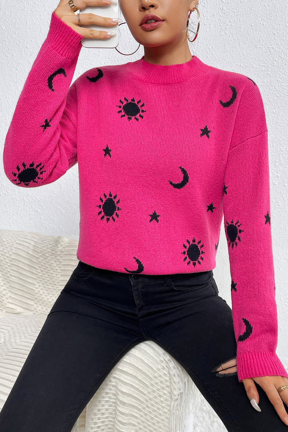 Hot pink acrylic knit sweater with mock neck and allover black sun, moon, and star print.