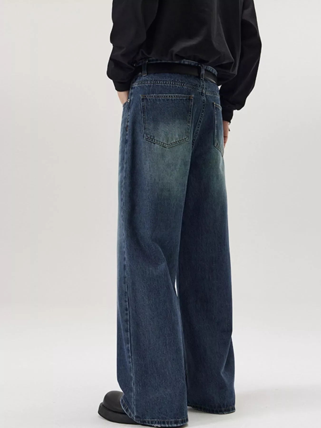 Men's wide-leg wash denim jeans in dark blue, relaxed fit, casual style.