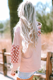 Dusty pink hoodie with floral patchwork sleeves and button details.