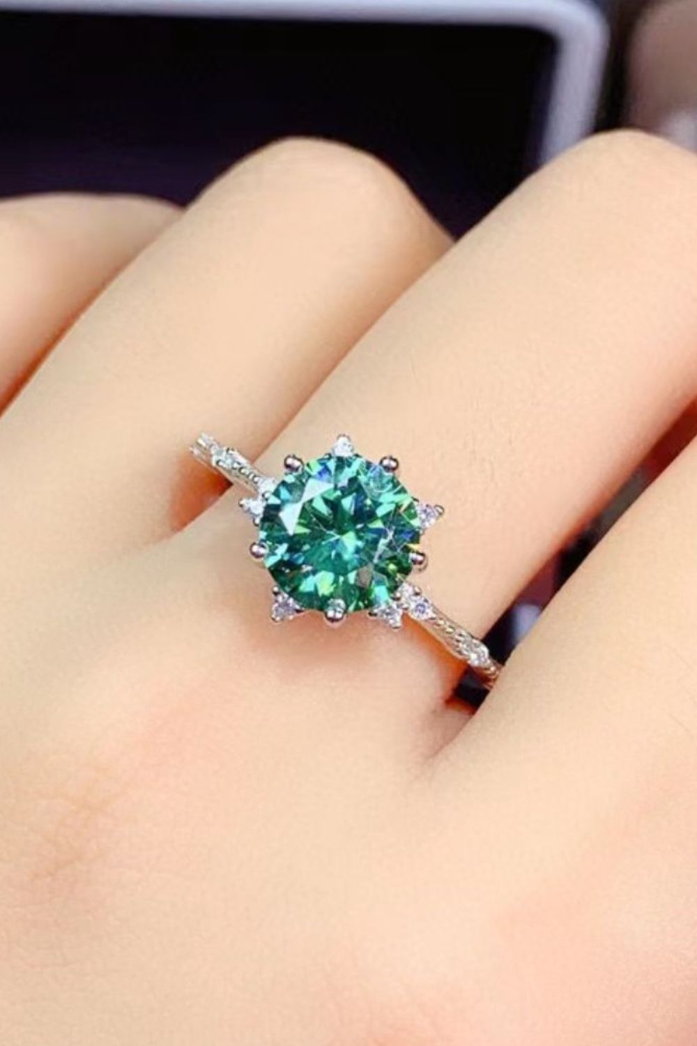 Emerald cut green moissanite ring with diamond halo on platinum band
