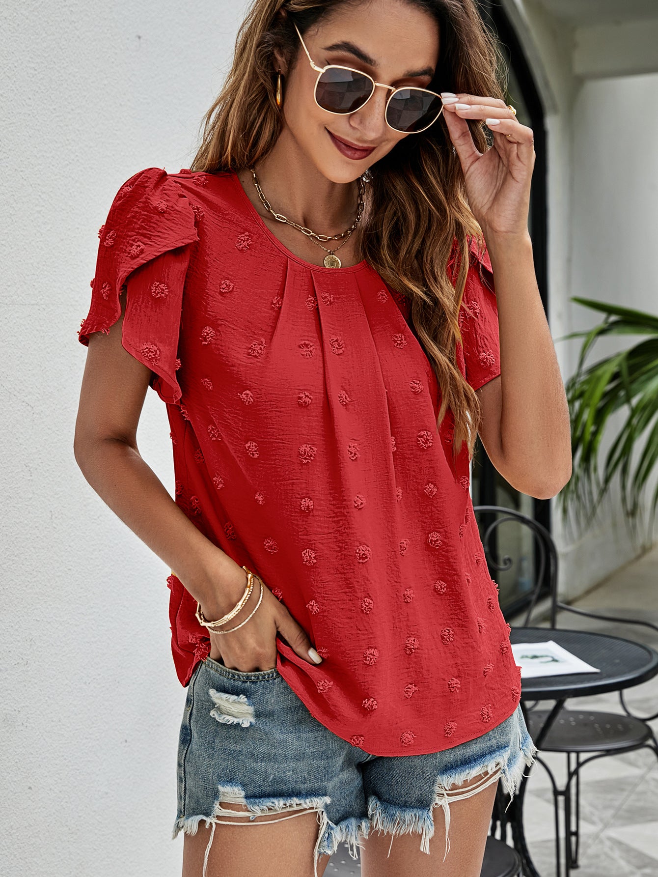 Red textured puff sleeve blouse with dot pattern and round neckline.