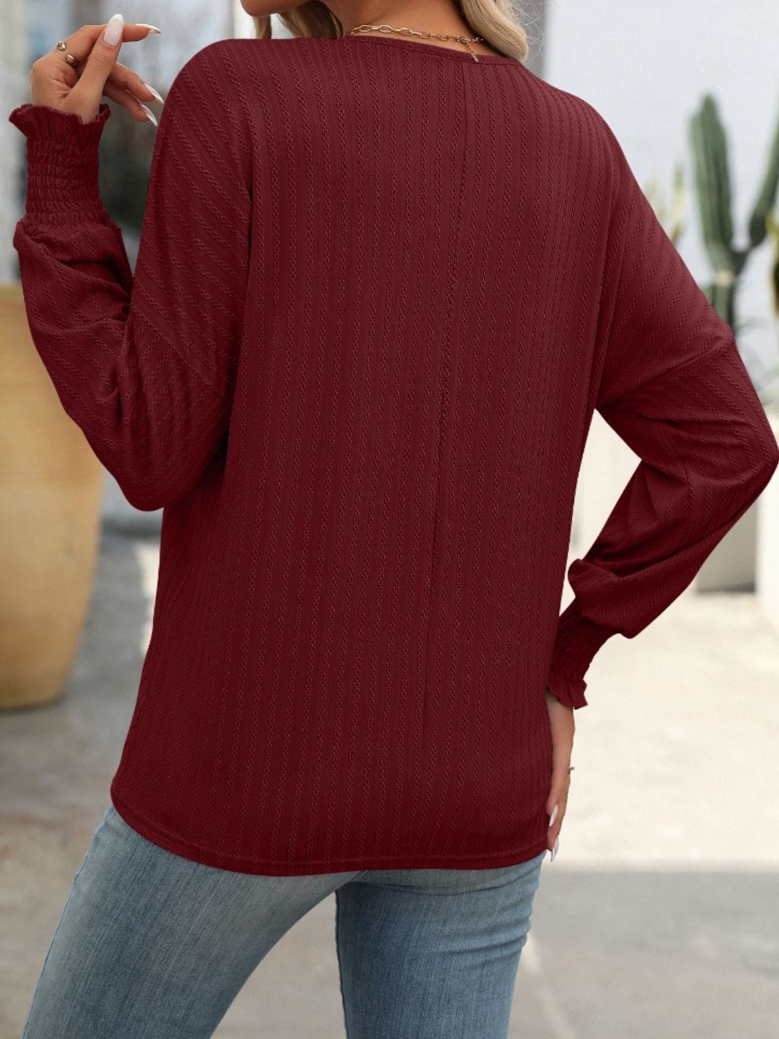 Burgundy textured sleeve blouson top with smocked cuffs.
