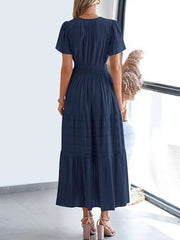 Dark blue ruched V-neck tiered midi dress with short sleeves and smocked waist.