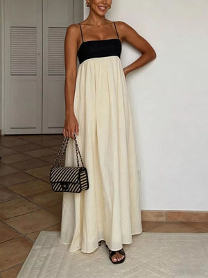 Elegant two-tone maxi dress with spaghetti straps, black bodice, cream skirt, and flowing silhouette.