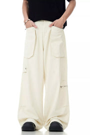 Relaxed cream cargo pants for men with multiple pockets and zipper details.