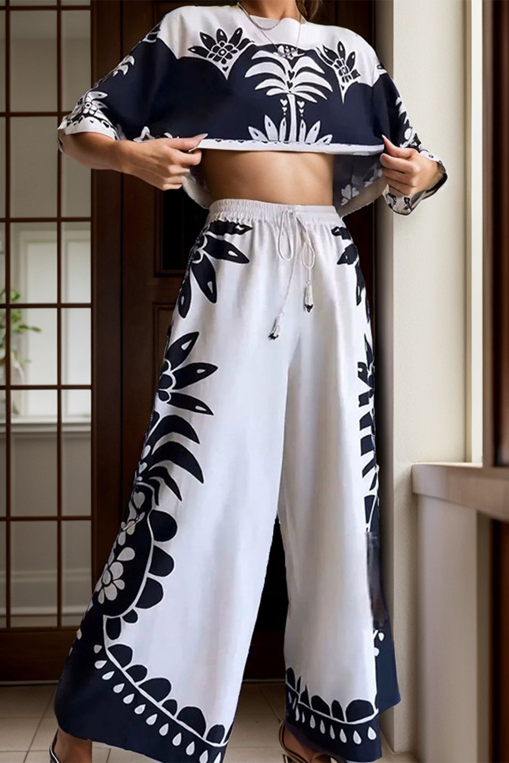 White crop top and palazzo pants set with monochrome botanical print and drawstring waist.