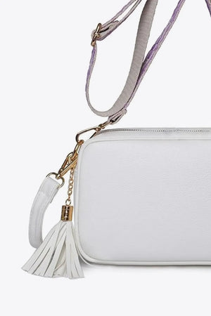 White textured crossbody bag with tassel detail and adjustable strap
