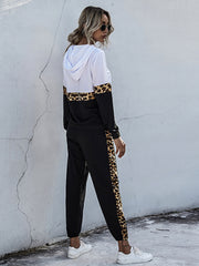 White and black colorblock lounge set with leopard trim on hoodie and pants.
