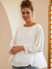 White tiered Swiss dot peasant blouse with long sleeves and ruffled cuffs.