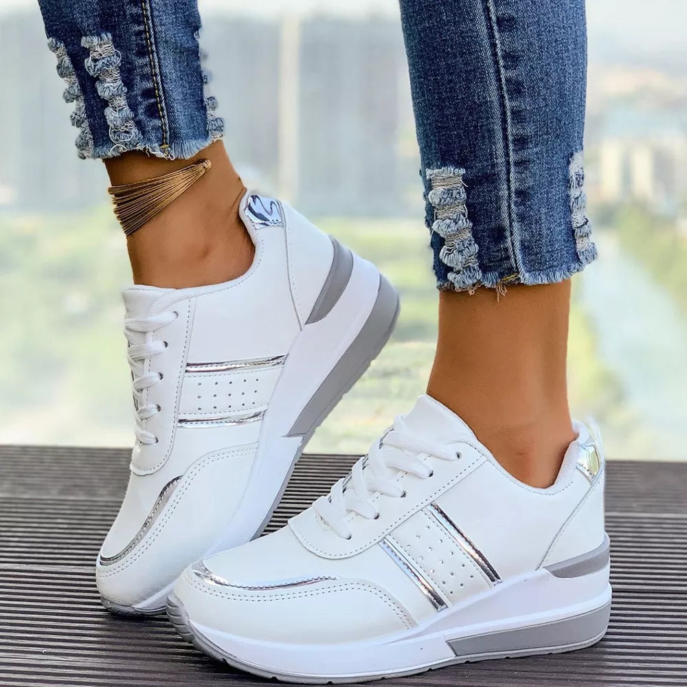 White lace-up sneakers with metallic accents and a chunky sole.