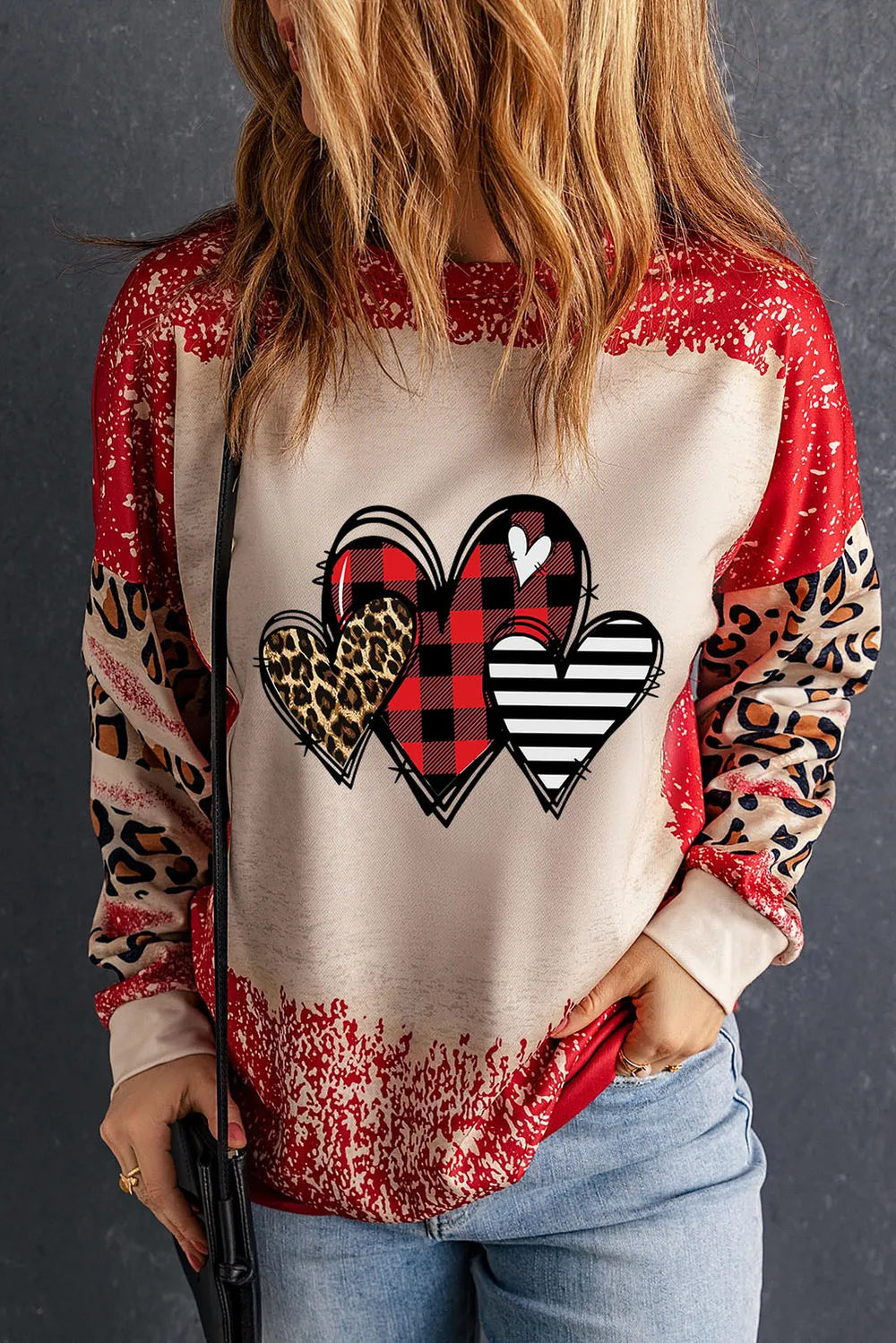 Patchwork sweatshirt with heart graphic, buffalo plaid, leopard print, and stripes.